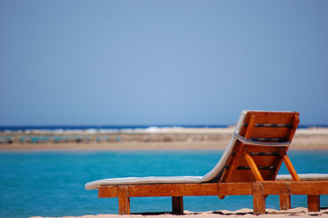 Picture of rest and peace - beach lounger on the sand against the backdrop of the azure sea