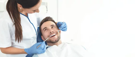 Foto op geborsteld aluminium Tandarts Jonge man bij de tandarts