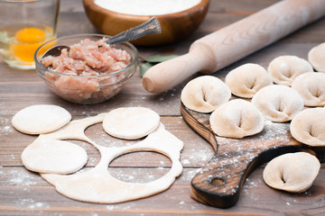 Fototapeta na wymiar The process of molding dumplings and ingredients for cooking on a wooden table