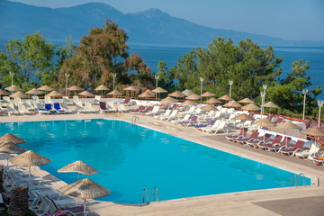Pool with sunbeds and umbrellas is near the sea.Concept of tourism