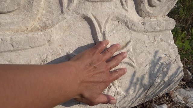 Antalya region, Turkey - 8th of July 2018: 4K Sagalassos ancient city tour - Handling a chrisscross engraved on the antient column basement