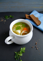 Russian chicken soup in a white dish with carrots, potatoes, vermicelli on a black background. top view. with black bread