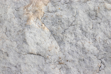 The texture of natural stone granite with small cracks. Background of natural stone gray with yellow spots. Texture with a crack.
