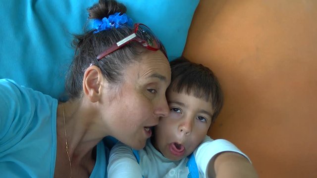 4K Selfie Mother kissing her child playing at zombie