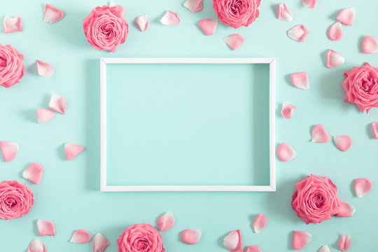 Beautiful flowers composition. Blank frame for text, pink rose flowers on pastel mint background. Valentines Day, Easter, Birthday, Mother's day. Flat lay, top view, copy space