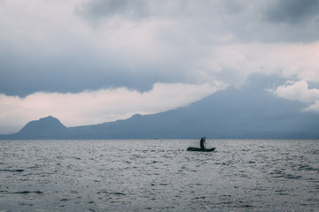Obraz premium man on kayak on lake in front of mountain