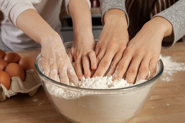 Fototapeta premium Mother and her daughter are baking a bread and having fun at the kitchen.