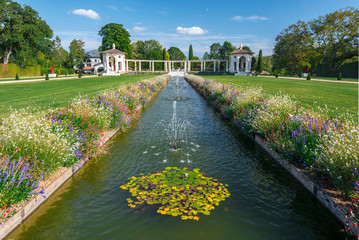 Central canal with fountains in French gardens of Villa Arnaga in Cambo-les-Bains, Two kiosks limit the gardens at background.  Basque Country, France.