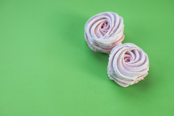Closeup Freshly baked dessert meringues marshmallow zephyr cake isolated on green background. candy...
