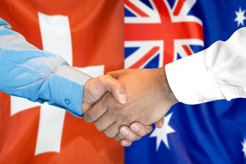 Business handshake on the background of two flags. Men handshake on the background of the Switzerland and Australia flag. Support concept