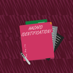 Text sign showing Hazard Identification. Business photo text process used to identify hazards in the workplace Colorful Lined Paper Stationery Partly into View from Pastel Blank Folder
