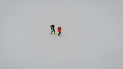 Aerial View of Two People Trekking in Snow