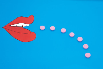 Side view at open mouth with pills on blue background