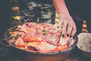 The woman's hand prepares fresh meat for baking