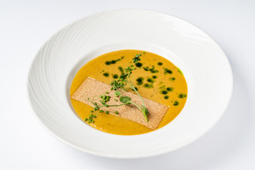 cream soup with pesto on the whtie plate