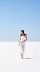 Happy girl in a white dress, salt lake Elton in the Volgograd region in Russia.