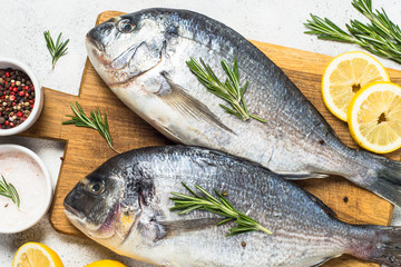 Raw dorado fish on cutting board on the table.