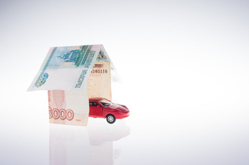 toy red car in the garage made of banknotes. real estate concept