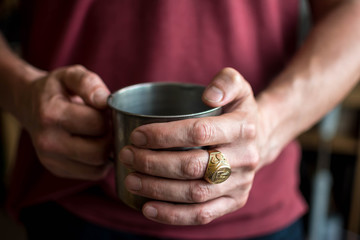 Fototapeta na wymiar in men's hands iron mug tea coffee