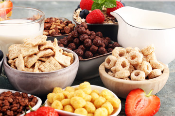 Cereal. Bowls of various cereals, berries and milk for breakfast. Muesli with kids cereals.