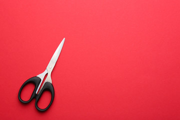 Pair of sharp scissors on color background, top view. Space for text