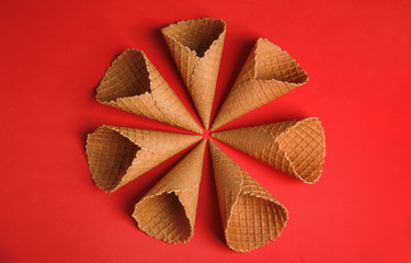 Waffle empty ice cream cones on color background, flat lay