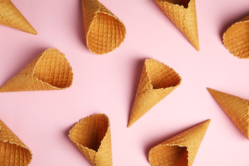 Waffle empty ice cream cones on color background, flat lay