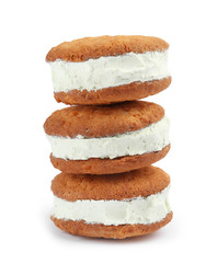 Sweet delicious ice cream cookie sandwiches on white background