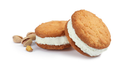 Sweet delicious ice cream cookie sandwiches and pistachios on white background