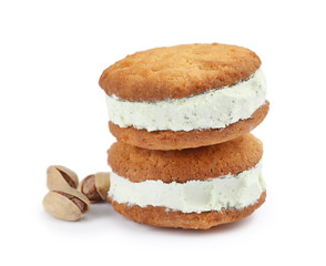 Sweet delicious ice cream cookie sandwiches and pistachios on white background