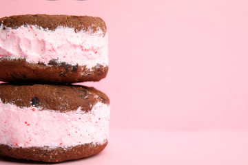 Sweet delicious ice cream cookie sandwiches on color background, closeup. Space for text