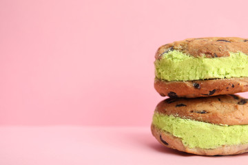 Sweet delicious ice cream cookie sandwiches on color background, space for text