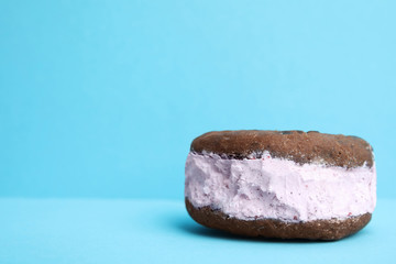 Sweet delicious ice cream cookie sandwich on color background, space for text