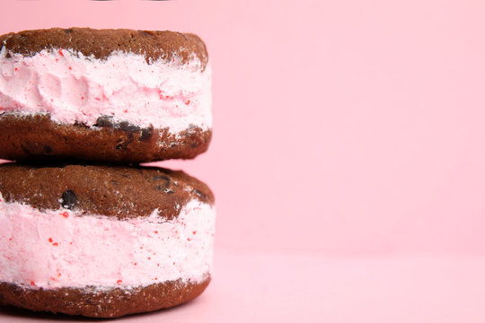Sweet delicious ice cream cookie sandwiches on color background, closeup. Space for text