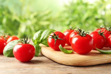 Board with fresh cherry tomatoes on wooden table