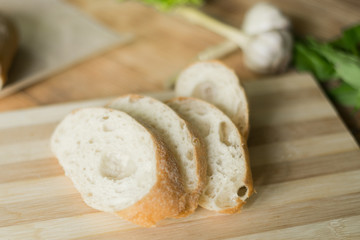 Sliced bread, ciabatta on wooden background. Preparation for the preparation of bruschetta.