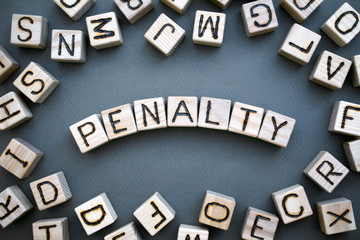 the word penalty wooden cubes with burnt letters, penalty for tax evasion, gray background top...