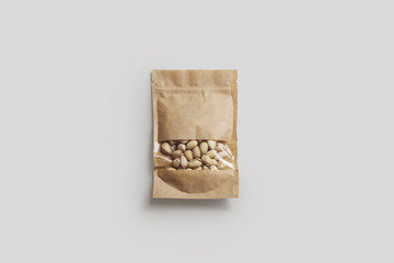 Pistachio Nuts in a paper bag package with window isolated on light gray background.Realistic...