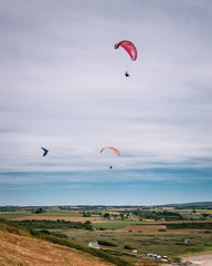 A hang glider and two paragliders over the beach of Kervijen in Brittany, France