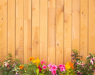 Fototapeta na wymiar Vertical wood fence made with recycled pallet. Clear and clean. Mix of flowering plants at the end