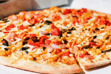 Delicious fresh pizza with shrimps , mushrooms and cheese close up in paper box