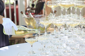Waiter pour champagne into glasses, closeup