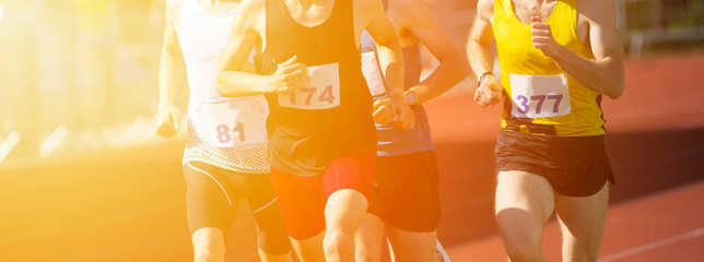 Athletics people running on the track field. Sunny day