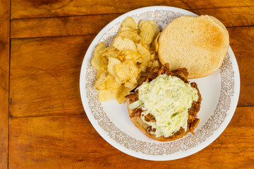 Pulled Pork BBQ Sandwich topped with Coleslaw and Served with Potato Chips