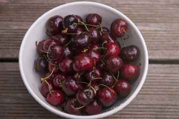 Fresh cherry on plate on wooden blue background. fresh ripe cherries. sweet cherries.