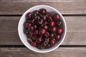 Fresh cherry on plate on wooden blue background. fresh ripe cherries. sweet cherries.