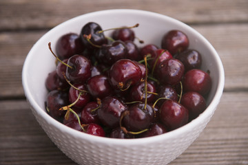 Fresh cherry on plate on wooden blue background. fresh ripe cherries. sweet cherries.