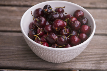 Fresh cherry on plate on wooden blue background. fresh ripe cherries. sweet cherries.