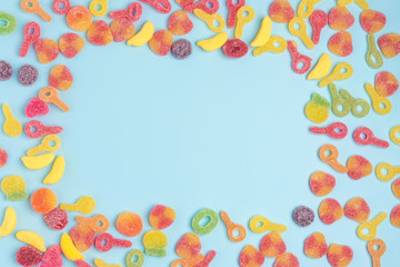 Blue paper background with sugary jellies and blank notepad. Place for your text. Cozy sweet background