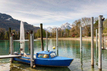 Fishing motor boat moored on Walensee lake on a sunny spring day. Weesen, Switzerland.